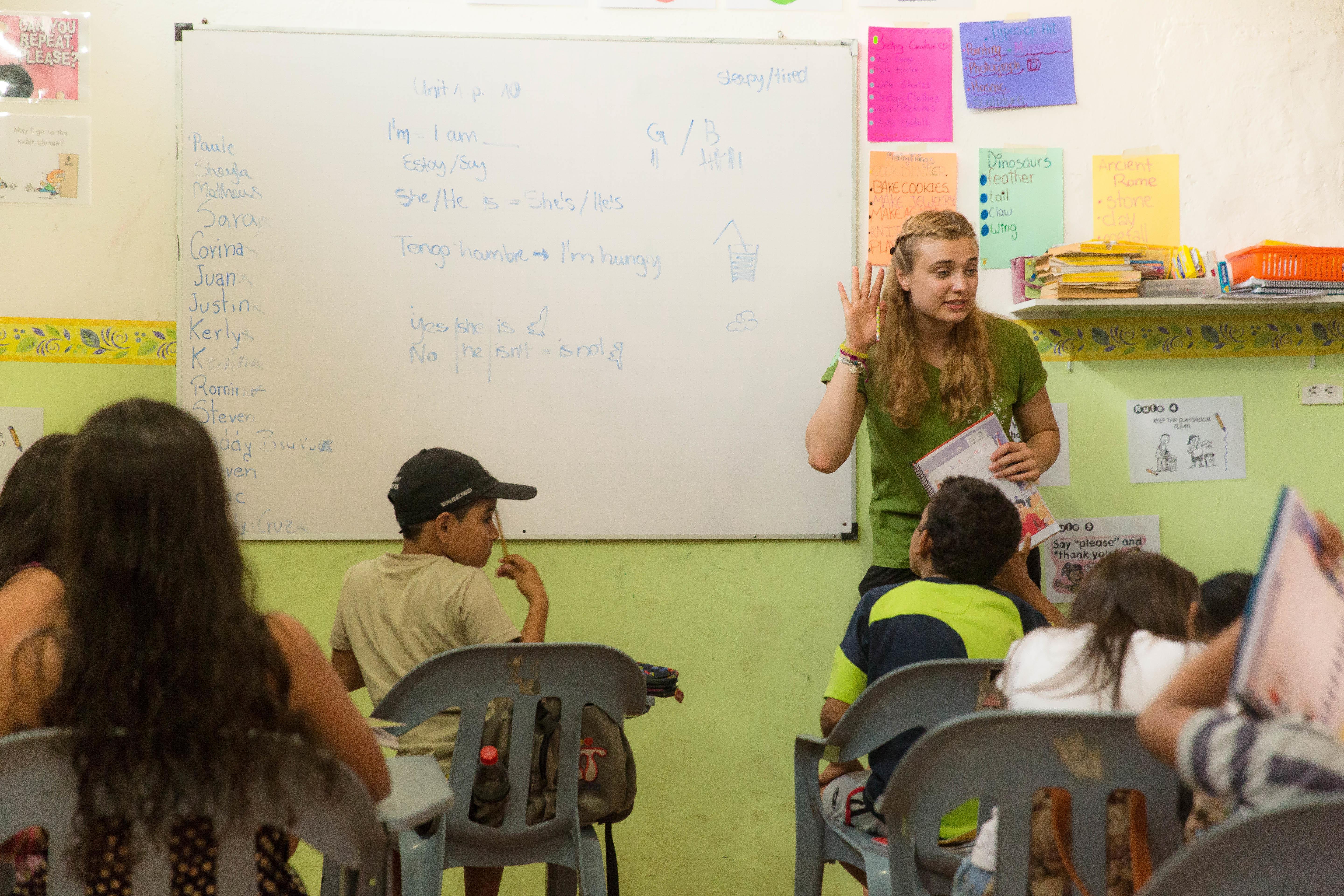 A volunteer asks students a question on one of our Teaching Projects abroad. A volunteer teaching abroad works with students on a Projects Abroad placement.